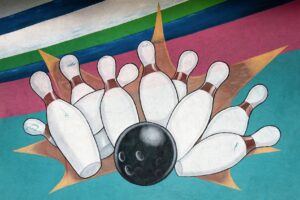 A painting of a bowling ball crashing into pins, the style of which is reminiscent of a 1980s bowling alley