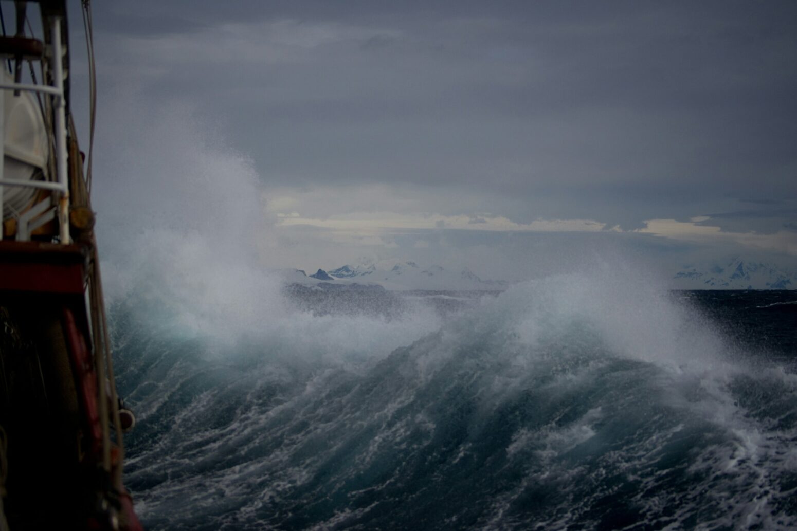 A view of a large wave crashing up against the side of a boat