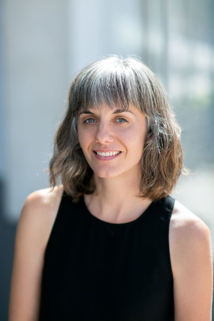 headshot of author with brown-gray hair and wearing a black tank top