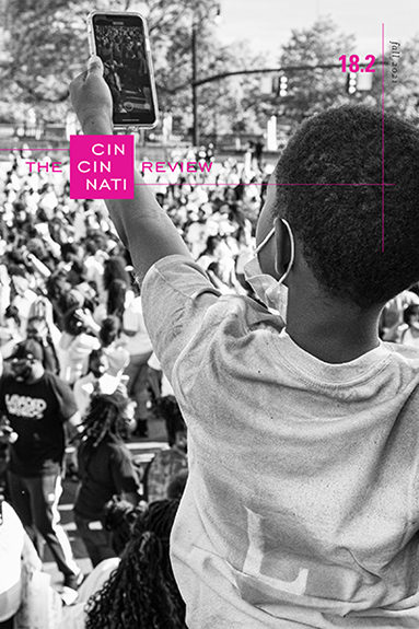 Cincinnati Review Issue 18.2 Fall 2021 cover. The magazine's square logo in pink in the upper left hand corner. A Black boy wearing a mask has the back of his head to the camera. He is lifting up a smartphone, filming a large crowd.