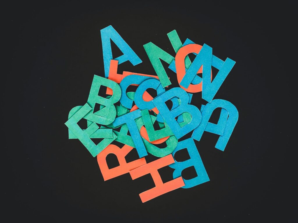Photo of cut out letters jumbled together on a black background