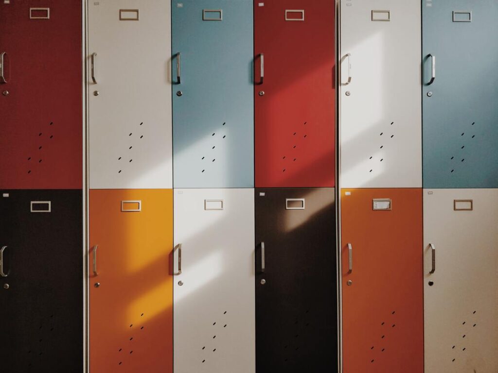 Wall of multicolored lockers: white, blue, orange, red, black.