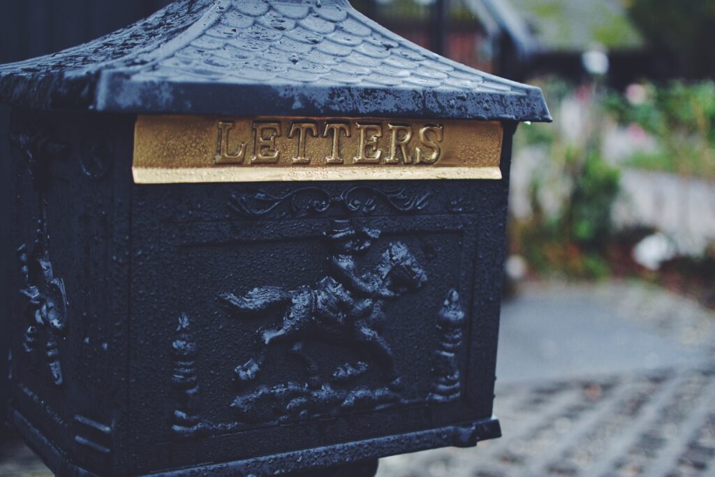 An old-fashioned iron mailbox depicting a horse and rider. The brass flap reads "LETTERS."