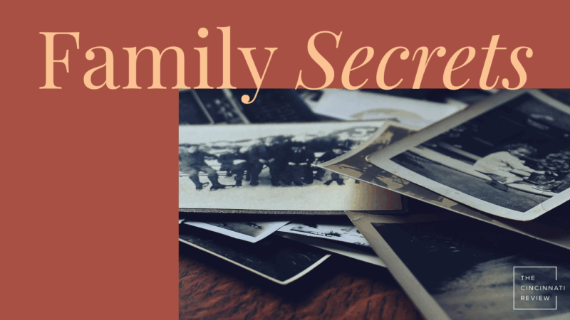 Headline "Family Secrets," in tan on a brown background. A photo of old black-and-white family photos laid out on a table.