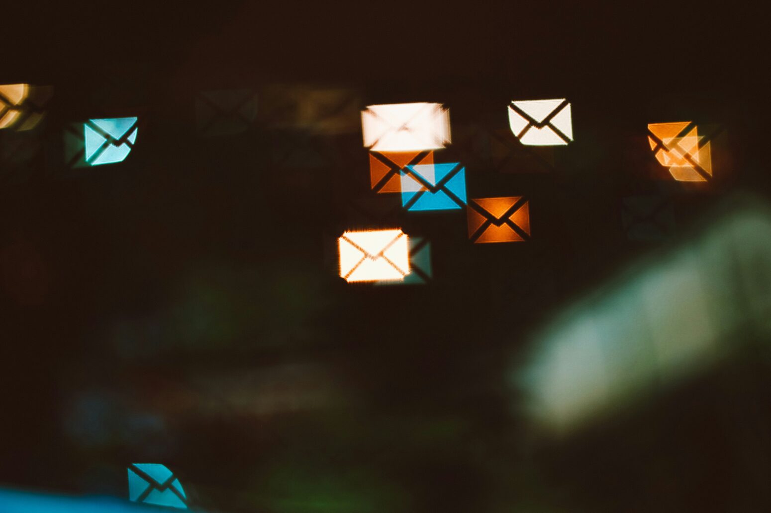 Email icons, in reds, blues, and whites, projected on a dark wall.