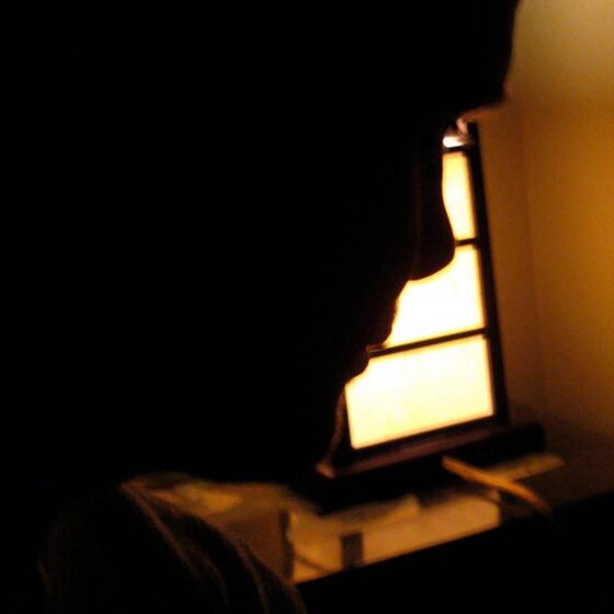 Dark silhouette of Vance Couperus's profile against an amber light.