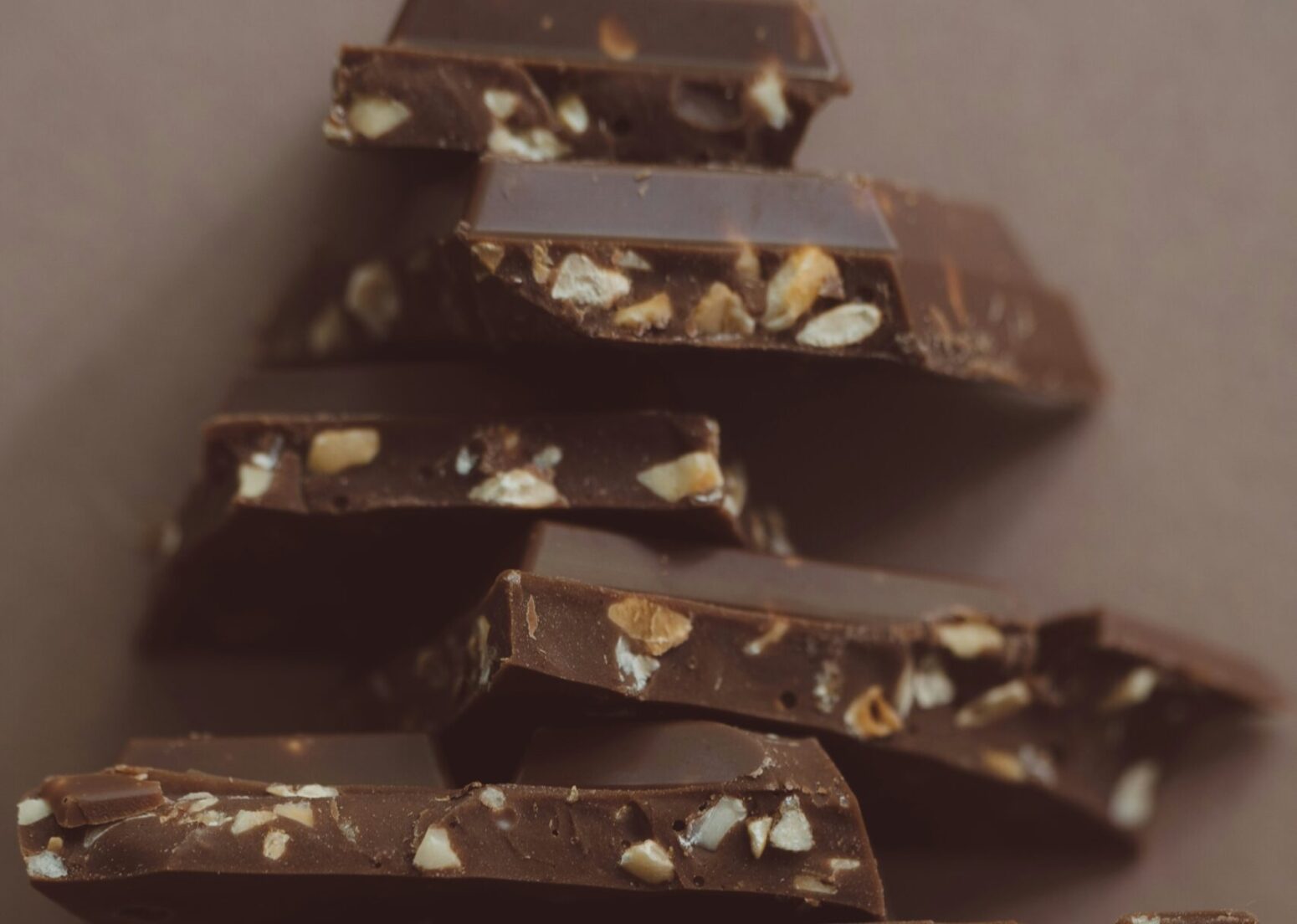 A stack of broken chocolate pieces filled with nuts.
