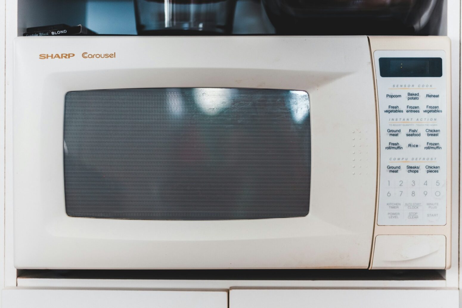 Close-up of the front of a white microwave, its door closed.