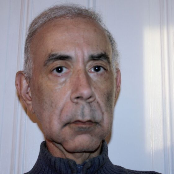 David Moolten, an older white man with white hair and dark eyebrows, does not smile.