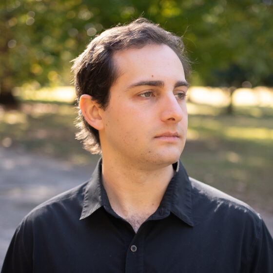 Side profile of Zack Fox Loehle, who is wearing a black button-up shirt.