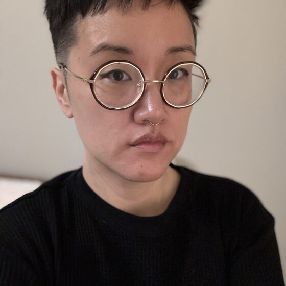 An Asian woman with short hair, glasses, and a septum ring.