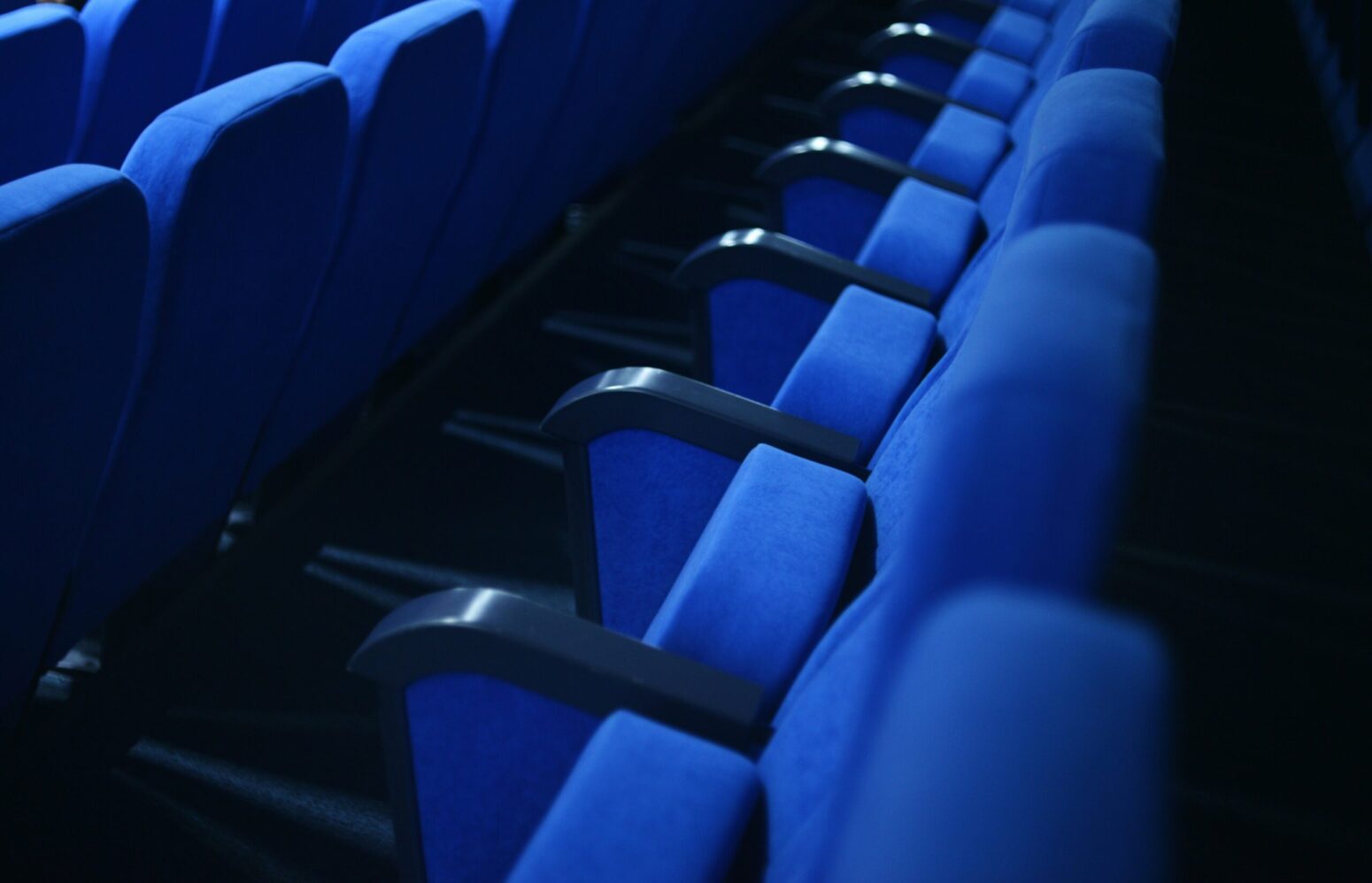A row of folded blue cinema seats