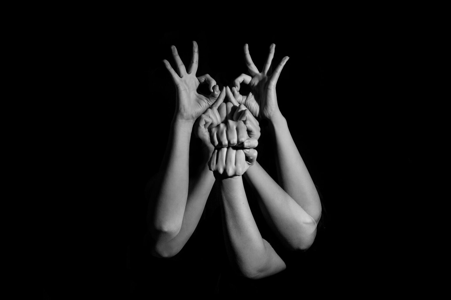 A group of hands collectively making a monstrous shape.