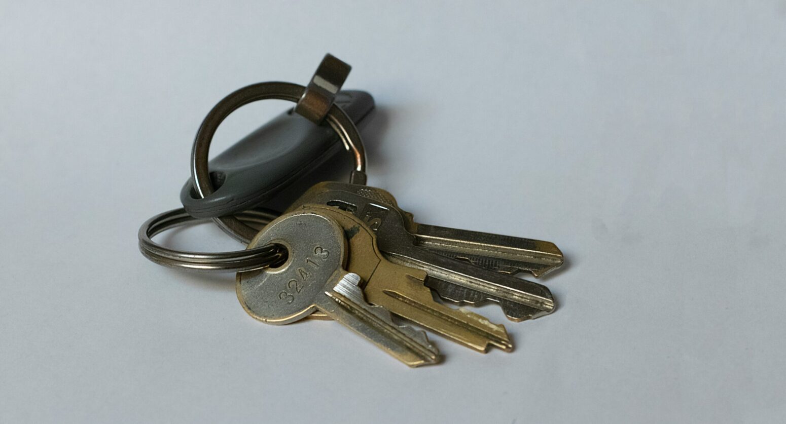 Close-up of silver and gold keys on a small keychain