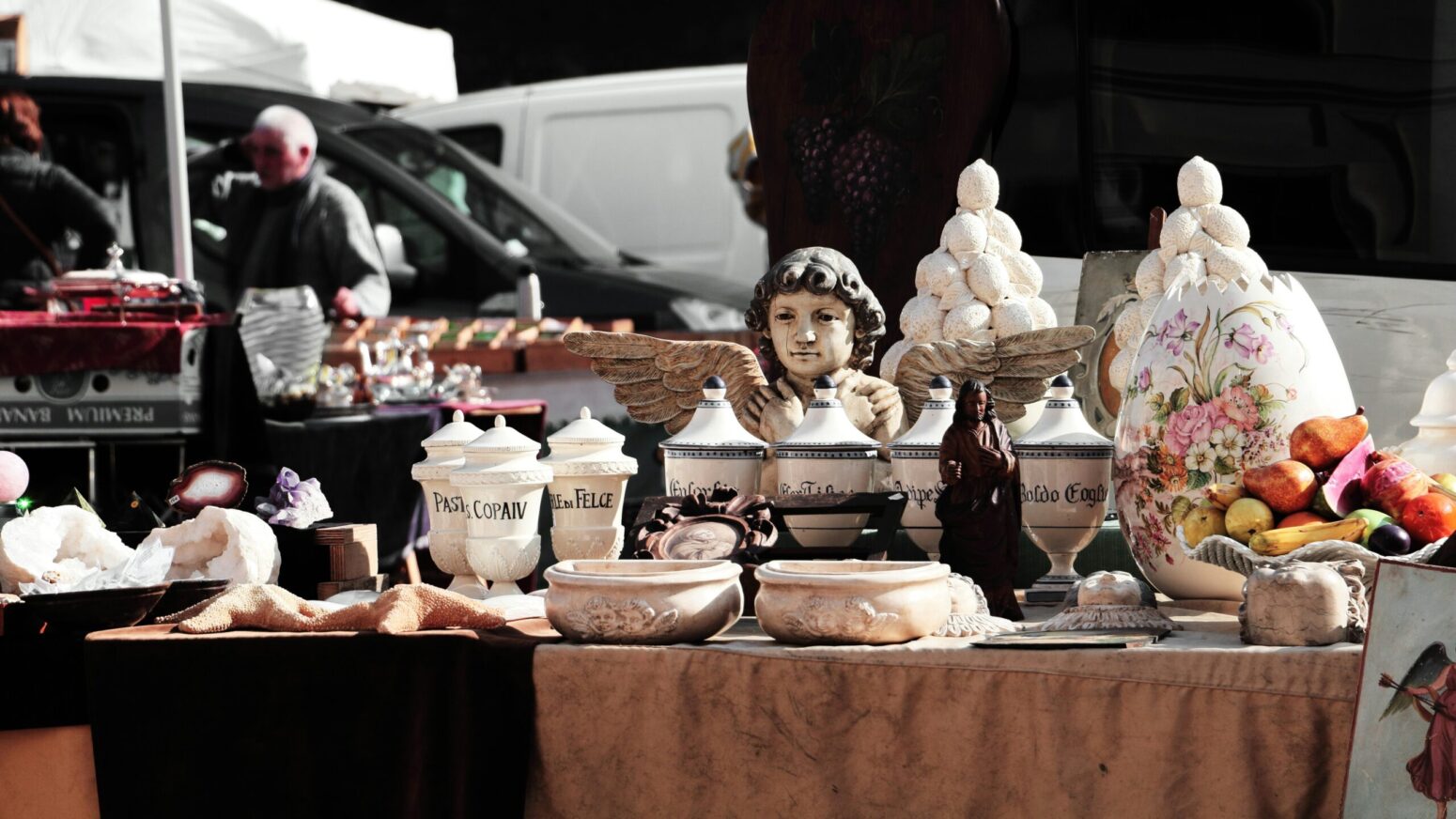 A number of ceramic and stone items on a table at a yard sale
