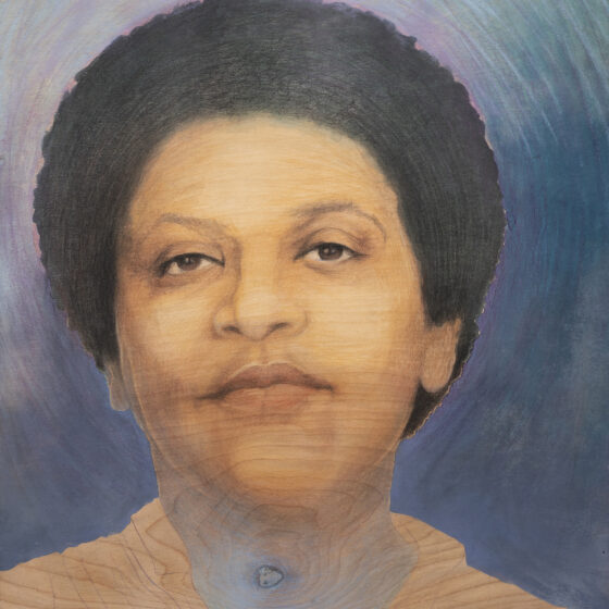 A painting of Audre Lorde, who was an American writer and poet known for her activism with the LGBTQ+ community and civil rights. She is a black woman with short, black hair and brown eyes. She is smiling, raising her chin slightly, and standing in front of a blue background. She wears an orange shirt.