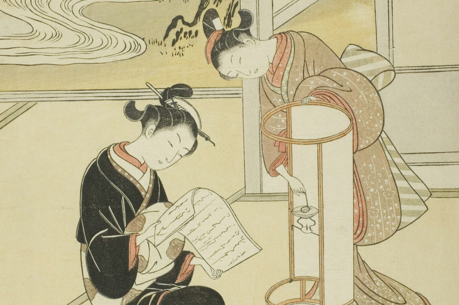 A portion of the painting "The Evening Glow of a Lamp" by Suzuki Harunobu. The painting portrays two women, one sitting to the left and one standing to the right. The woman on the right is placing a light into a large lamp. The woman on the left is reading something on a piece of paper. They are both in an open house with a river in the background to the left.