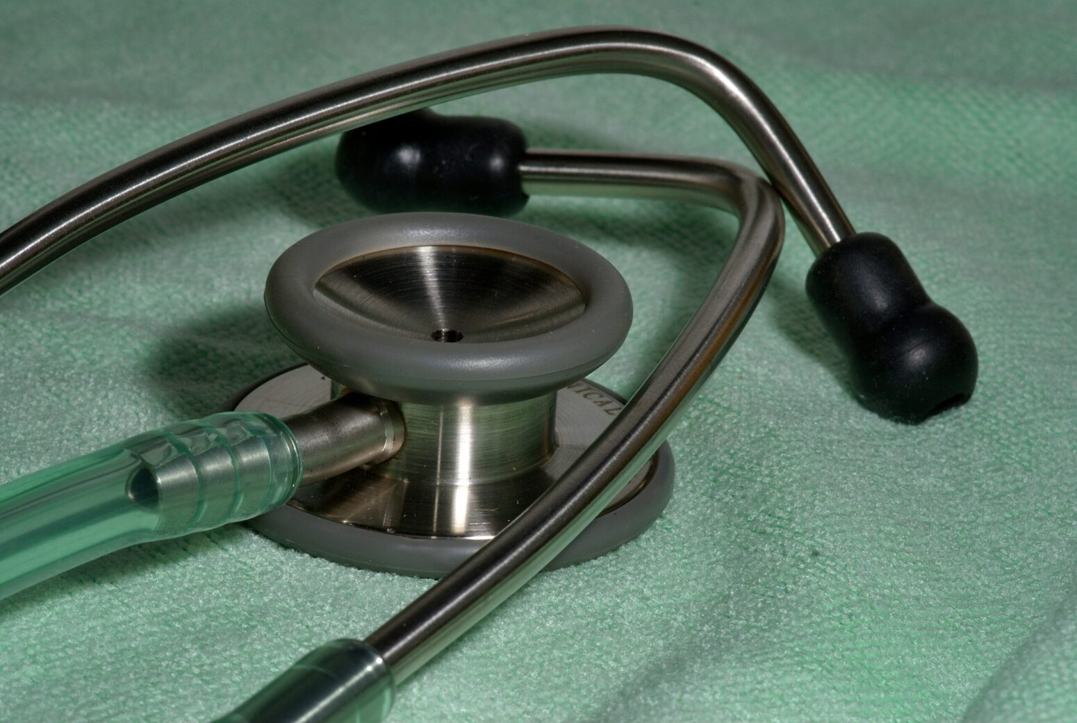A stethoscope on a green surface.