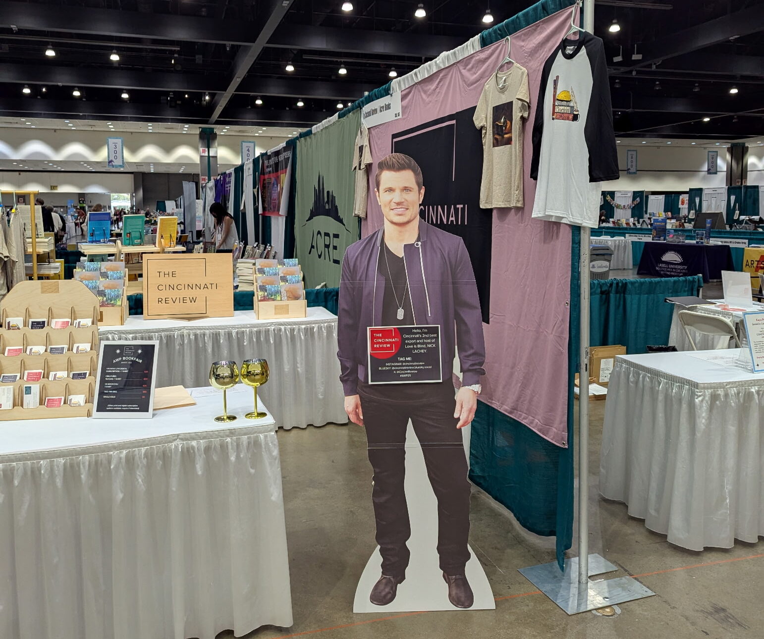 A life-size cardboard cutout of Nick Lachey stands in front of the Cincinnati Review booth at AWP Los Angeles.