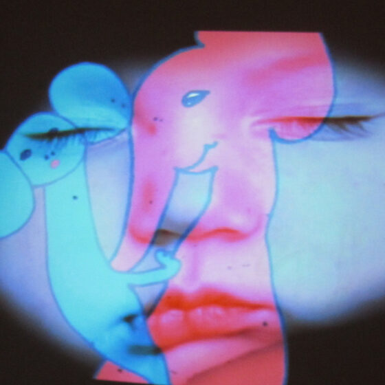 A blue projection of a little boy's face, underneath a projection of a drawing of a red, mother elephant holding a blue, baby elephant.