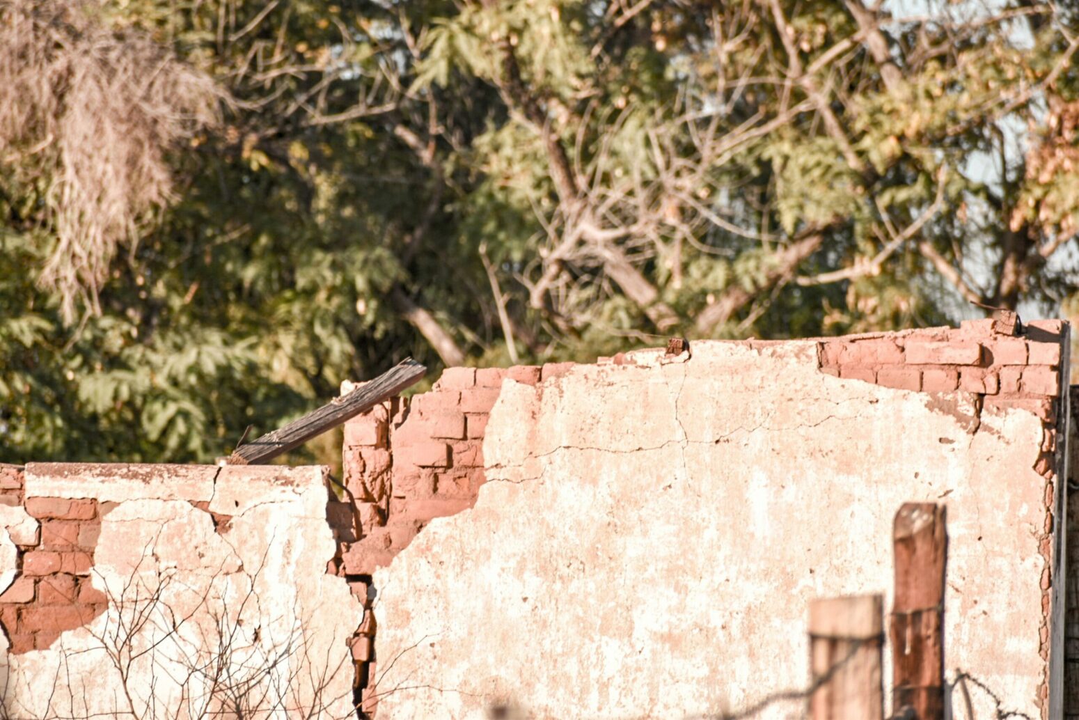 An old, brick fence covered in plaster.