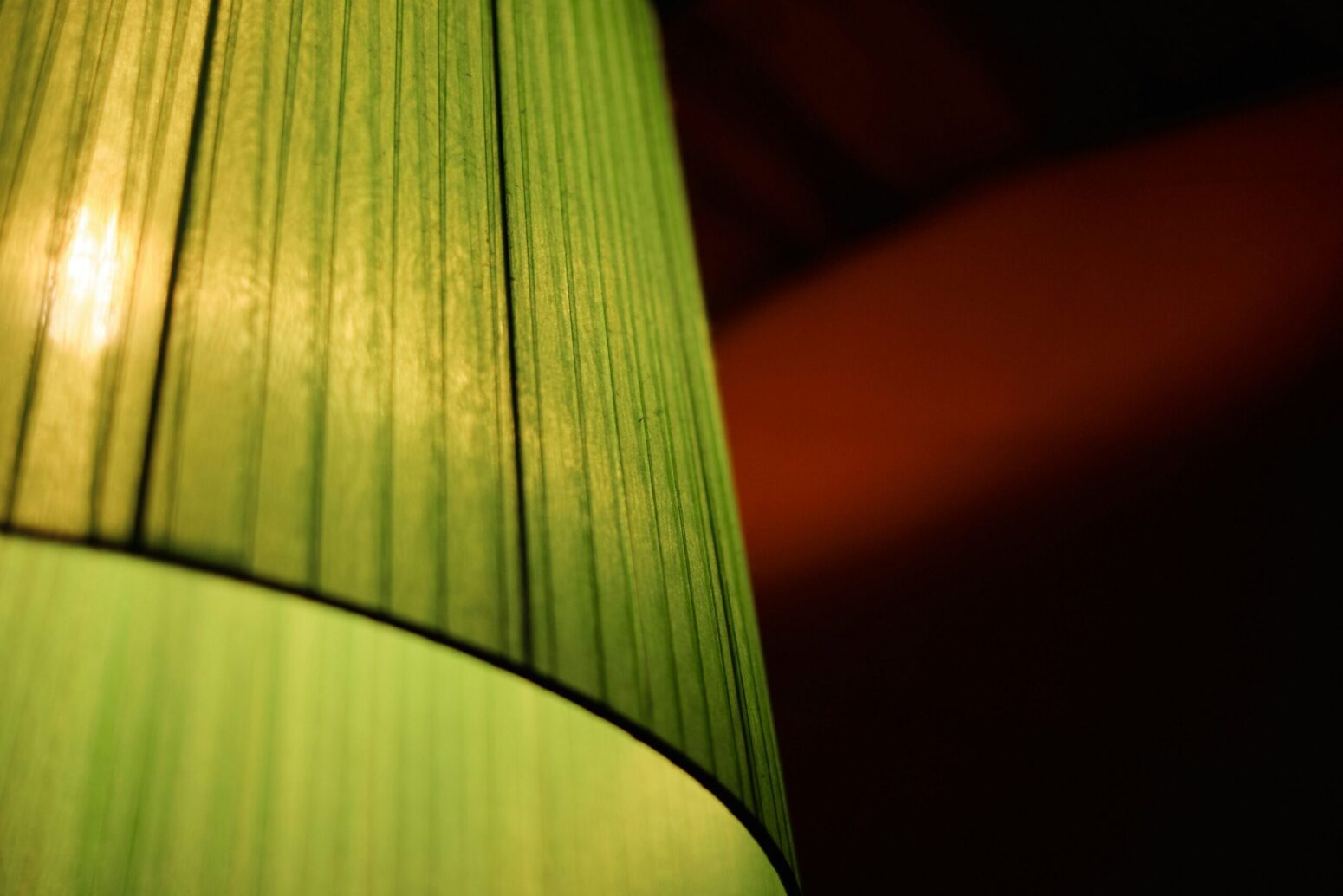 A close-up of a green lamp shade on a dark background
