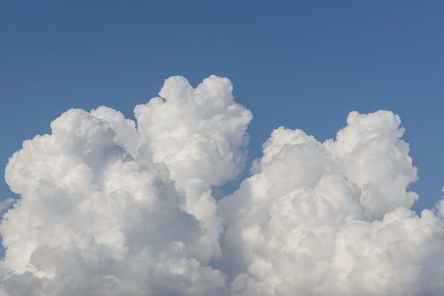 Fluffy, white clouds against a blue sky
