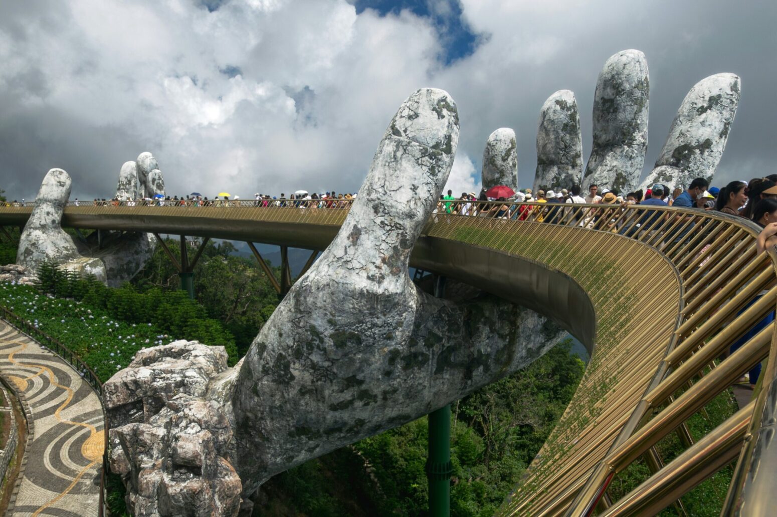 Golden Bridge in Da Nang, Vietnam. A large, round, pedestrian bridge held up by two, large, metal hands coming out of the ground