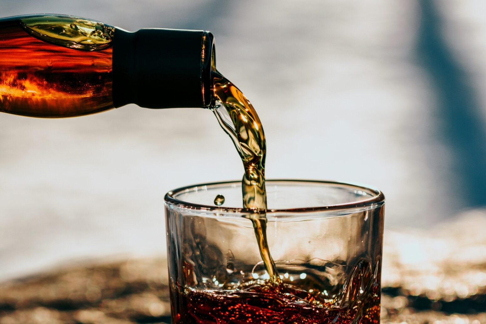 A bottle of brown liquid being poured into a