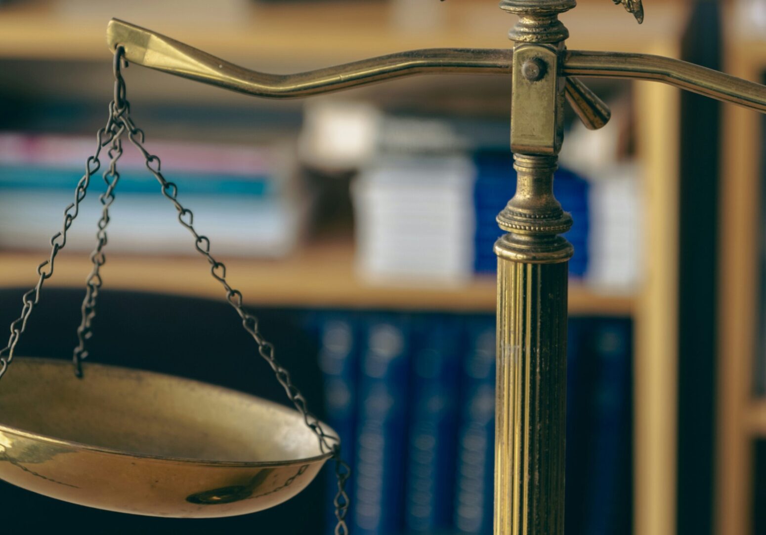 A side view of a small pair of golden scales sitting in a legal office