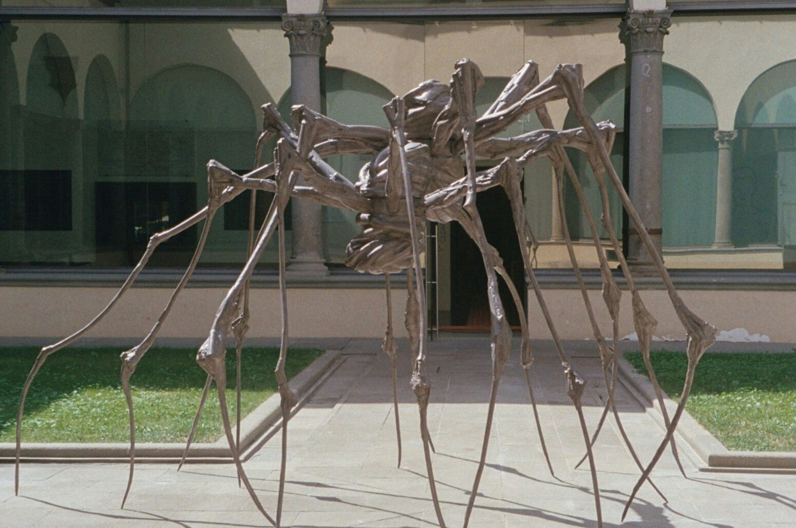 "Spider" by Louise Bourgeois depicting large, bronze statute of a spider standing outdoors.