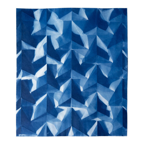 A folded cyanotype phogograph with a repeating pattern of triangles making up what appears to be a network of cells.