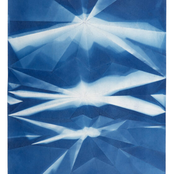 A folded cyanotype, in blue-and-white, with a repeated pattern that resembles a starburst.