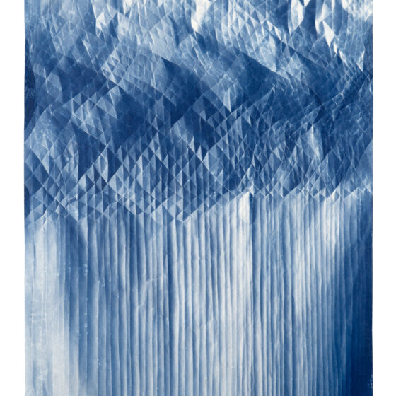 A folded cyanotype showing intricate patterns of diamonds and lines.