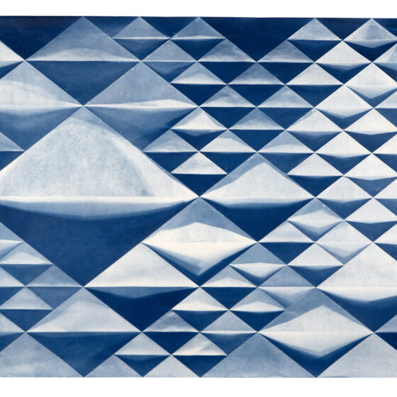 A folded cyanotype photograph with a repeating diamond pattern in different sizes, in blue-and-white.