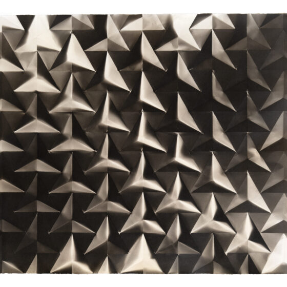 A folded palladium photograph with a repeating triangle pattern in black-and-white.