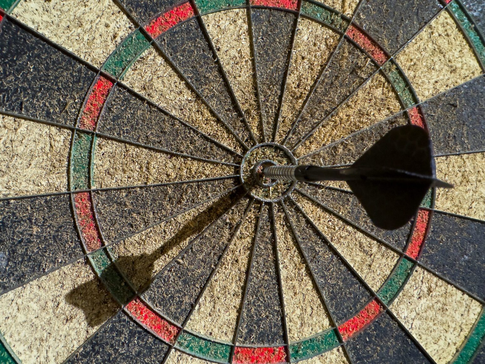 This photograph shows a dartboard with the dart landing right in the middle.