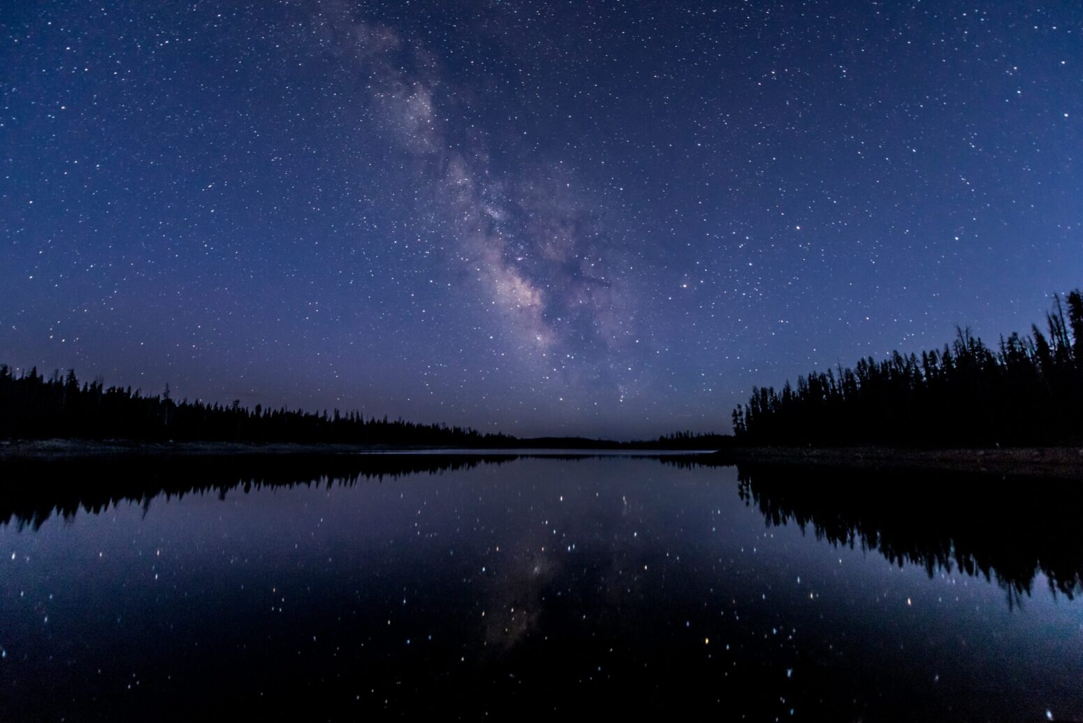 This picture was taken at Lost Lake in the Uinta Mountains. The Milky Way is visible across the horizon, with the photograph being taken just after the sun had gone down and the sky was still slightly blue.