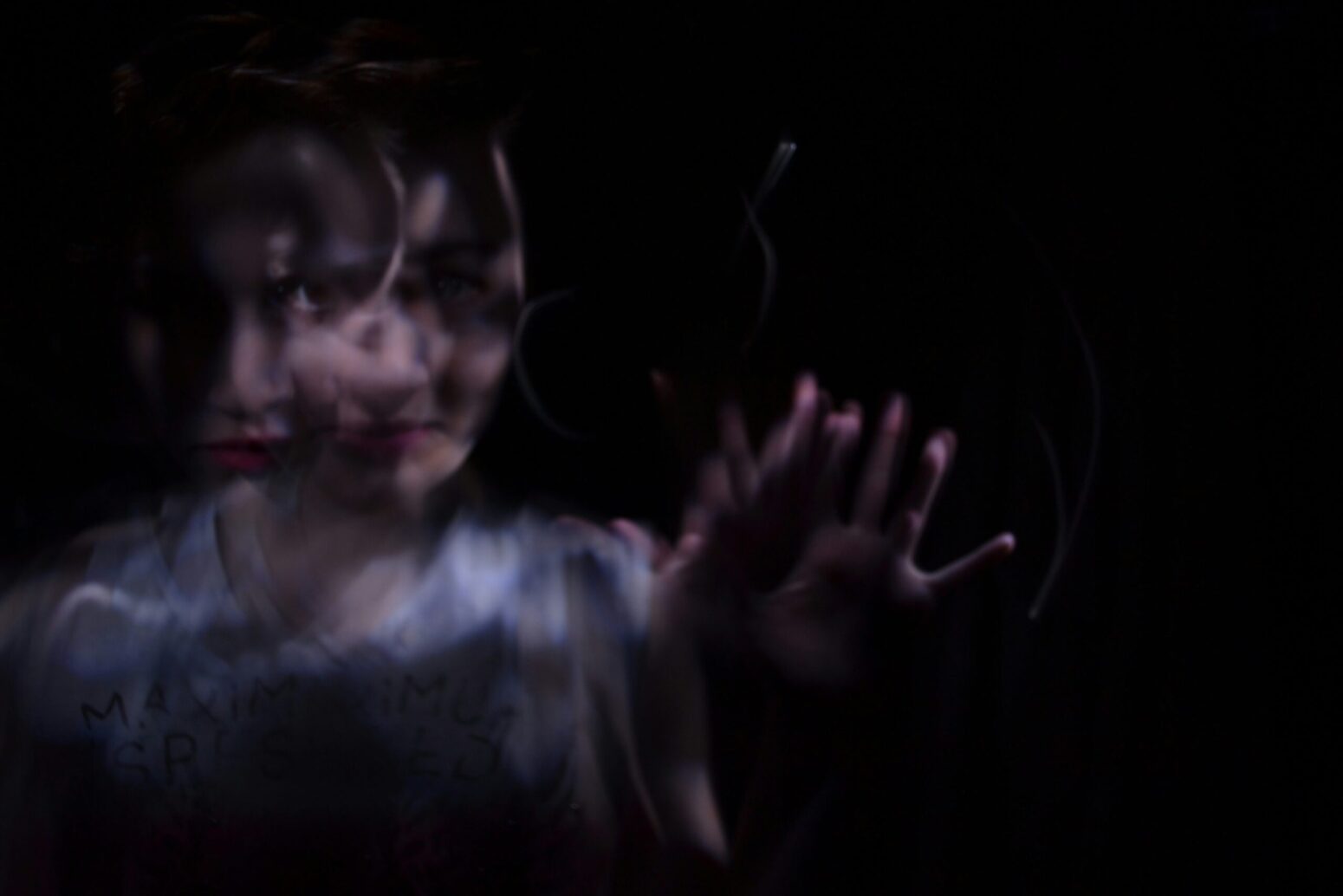 This timelapse photograph shows a woman holding her hand out.