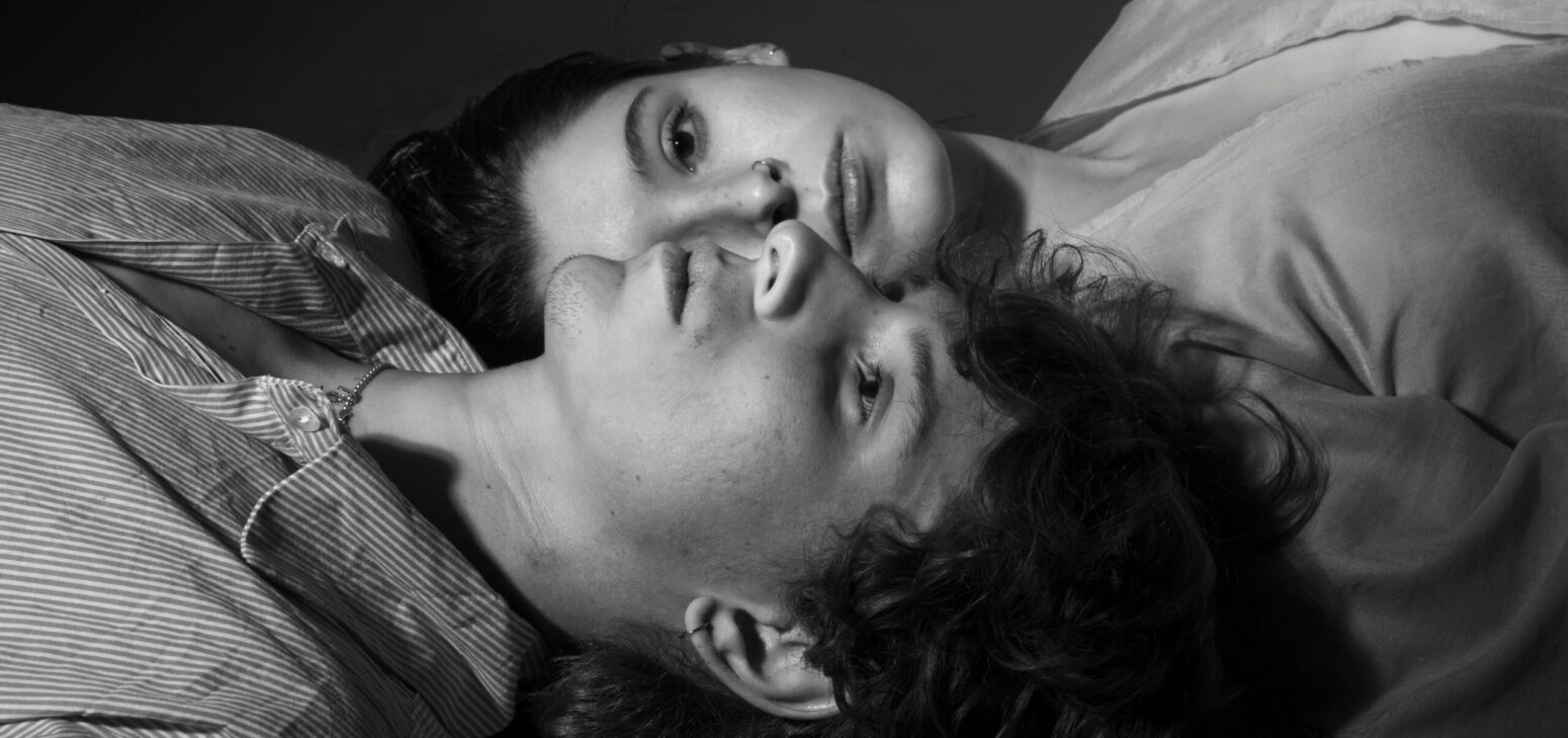 This black and white photograph shows a man and a woman lying down.