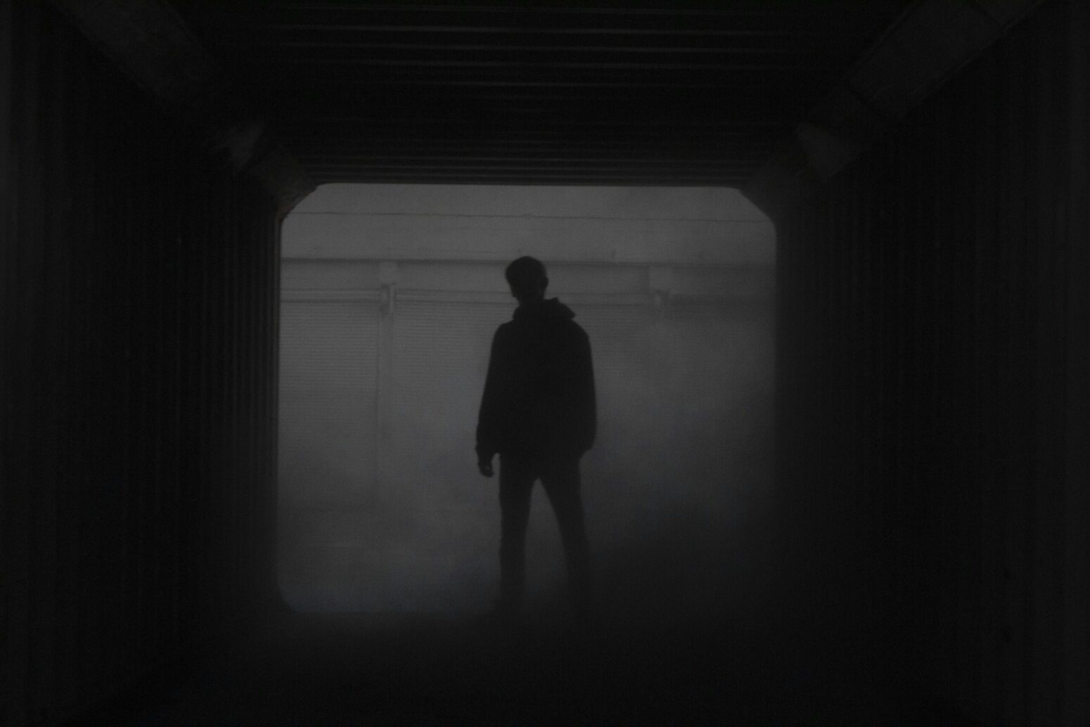 This photograph shows a figure covered in the shadows of the environment around this individual.