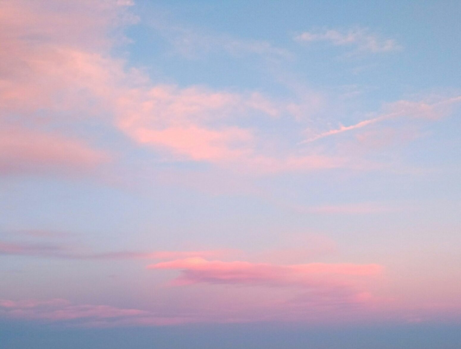 This photograph shows a sky tinted with rose and golden, presumably with a sunset happening that cannot be seen in the photograph.
