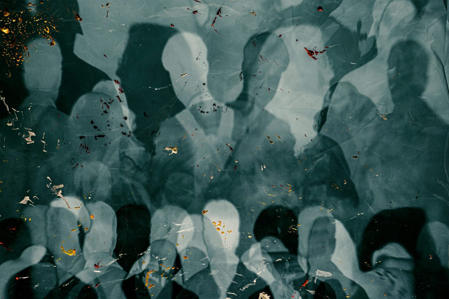 This photograph shows a group of people standing around one another in shades of blue and white.