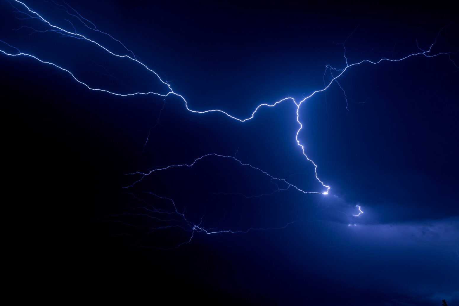 This photograph shows several strands of lightning in the sky at night.