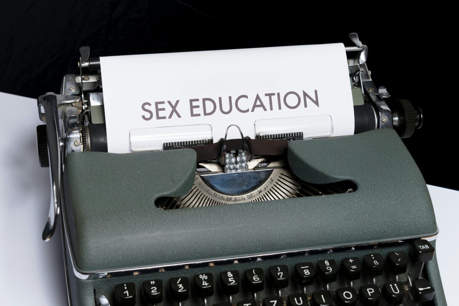 This photograph shows a typewriter with the words "SEX EDUCATION" being printed on the paper.