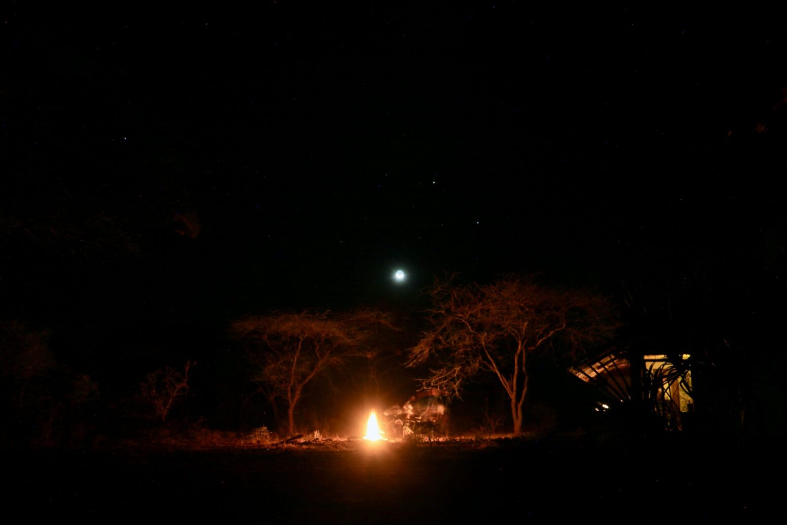 This photograph shows a fire with a faint safari being present at night.