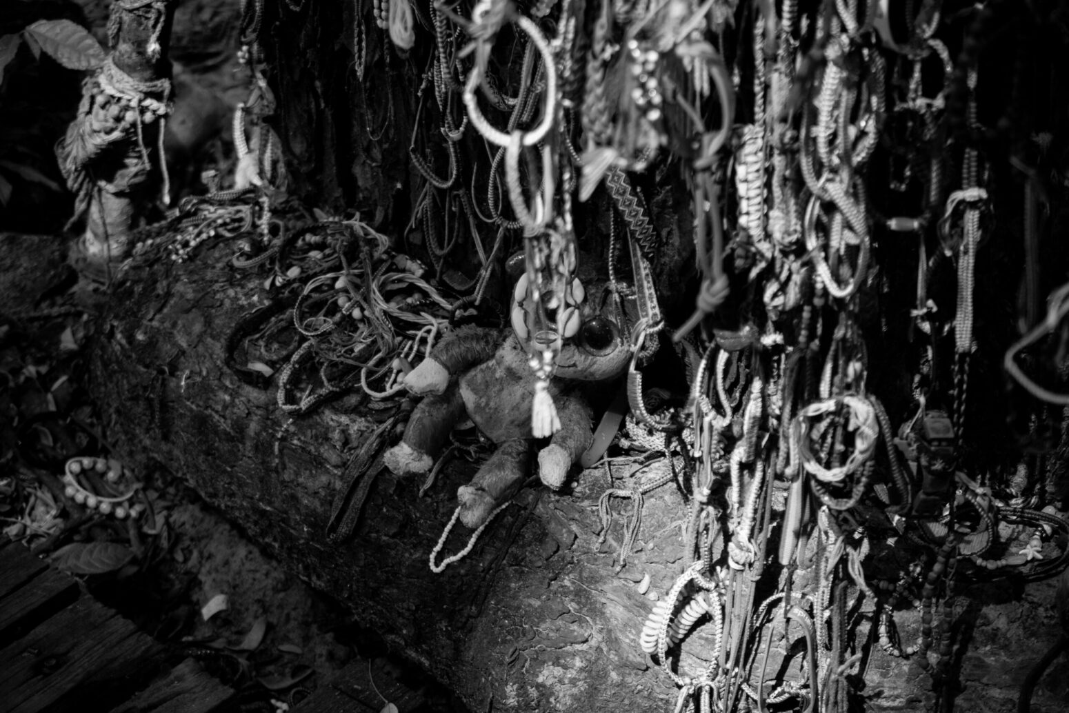 This photograph shows a faint plush of sorts, surrounded by many chains, wristbands, and more.