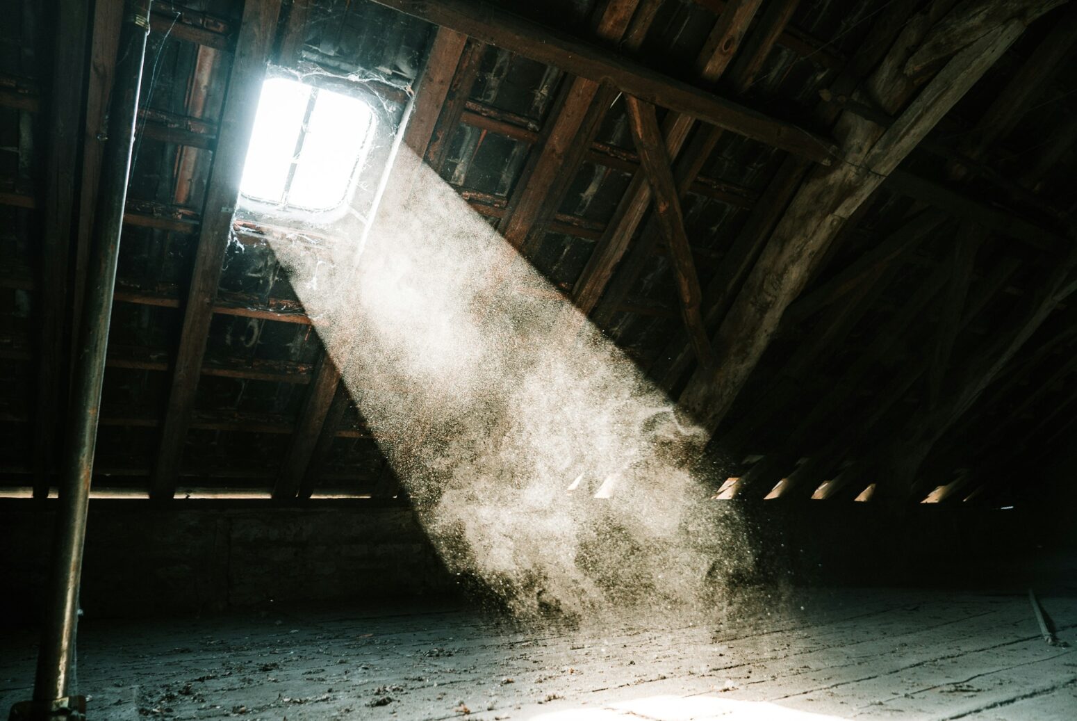 A stream of sunlight slanting in from an attic window, illuminating the dust.