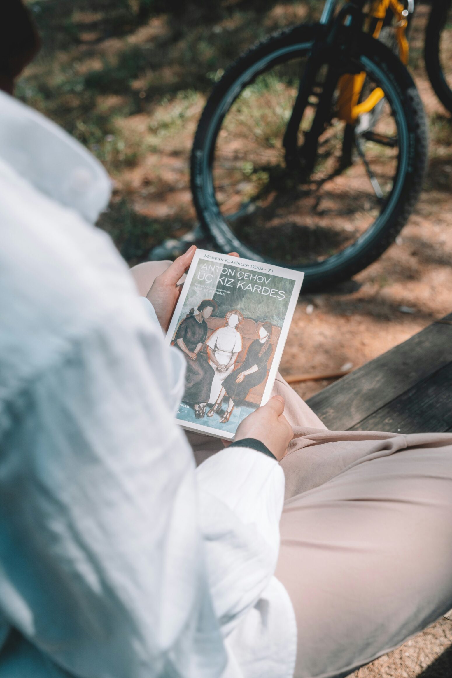 An anton chekhov book held by a person overlooking their shoulder
