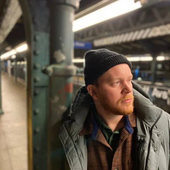 a man with a black beanie and beard staring into the distance